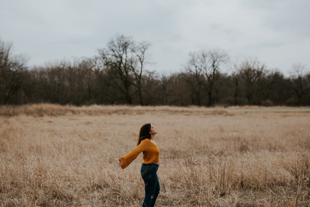 donna in piedi sul campo di erba marrone