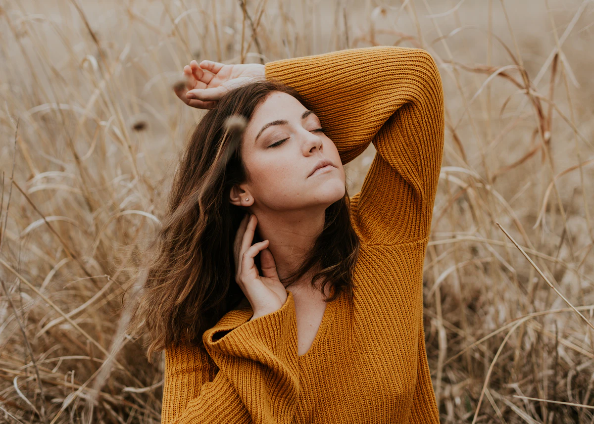 Woman in a chunky orange knit pullover outdoors
