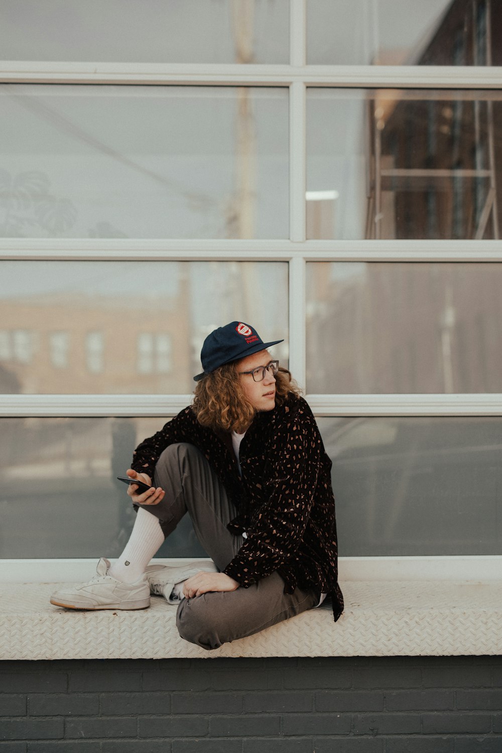 man sitting on metal surface looking at his left