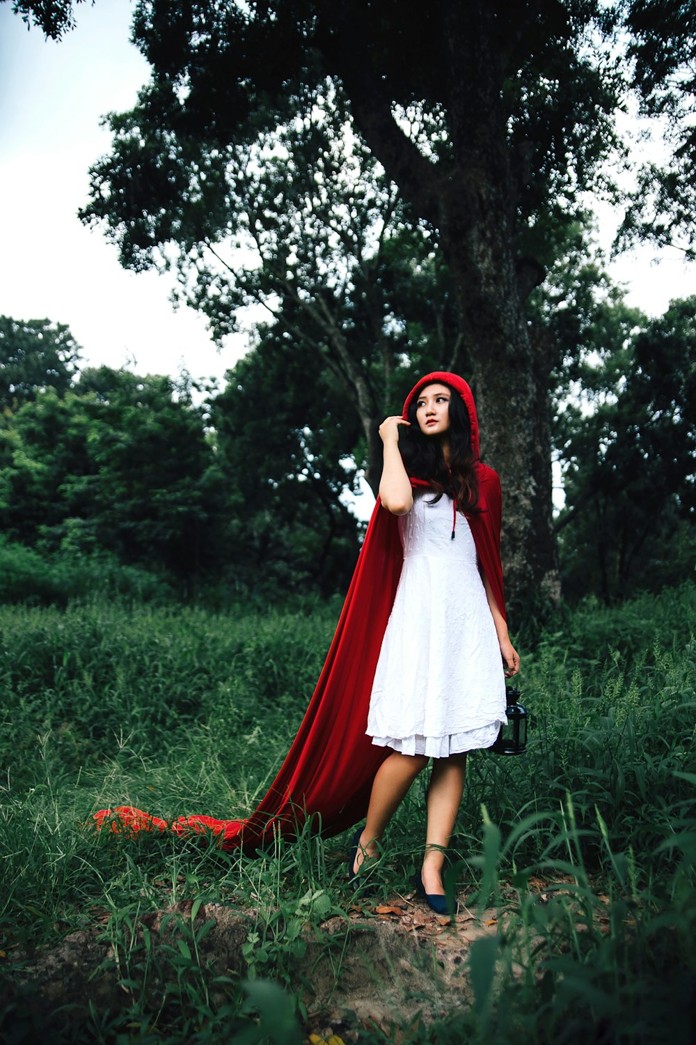 woman cosplaying little riding hood near tree