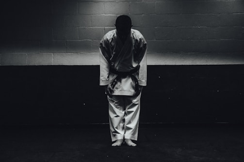 An instructor demonstrating a Wing Chun stance in a clean, minimalistic studio.