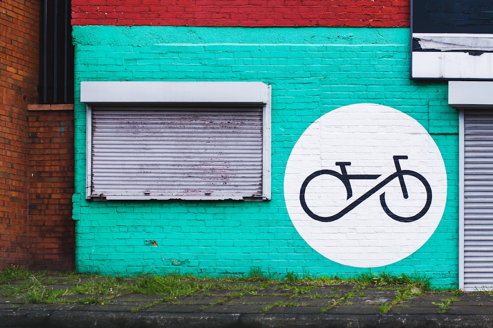 white and teal concrete house with graffiti