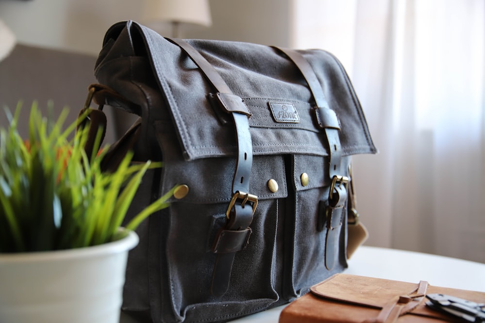 black leather satchel bag on white top