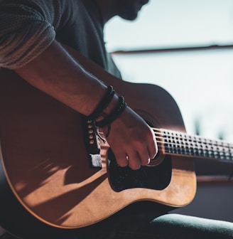 man playing acoustic guitar 