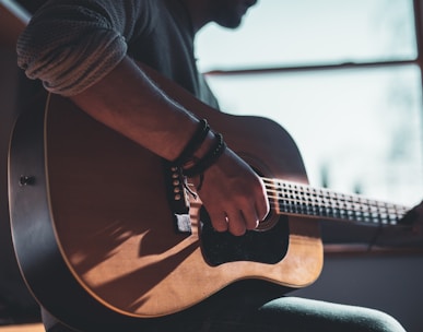 man playing acoustic guitar 