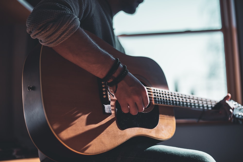 어쿠스틱 기타를 연주하는 남자 선택적 초점 사진