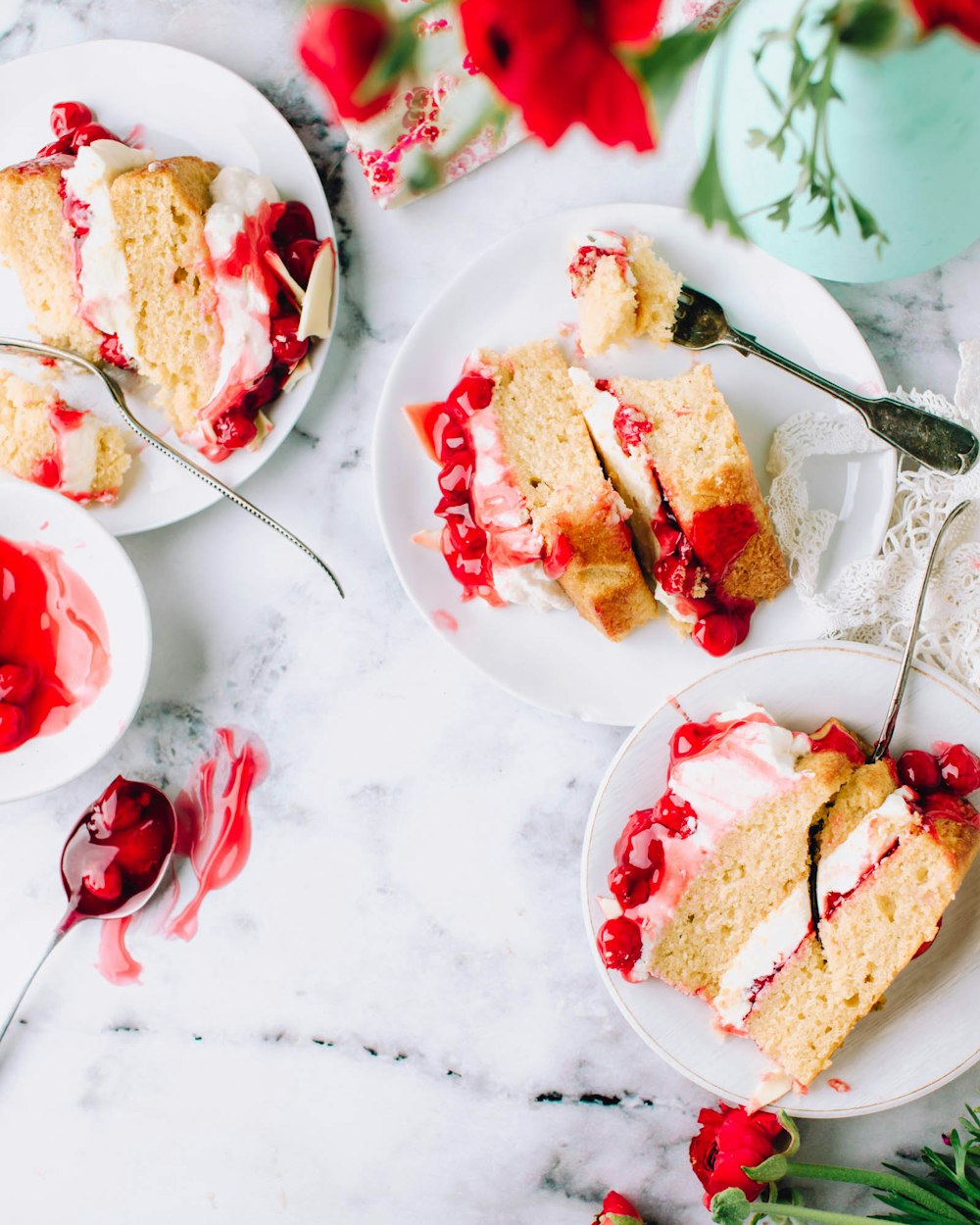 sliced cakes beside stainless steel forks on round white ceramic plates