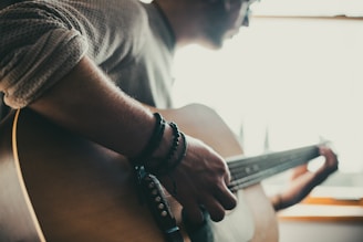 homem tocando violão dentro de sala