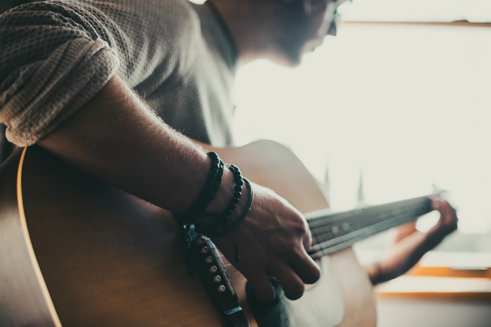 man playing guitar inside room