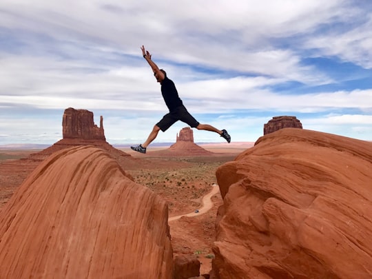 man jumping on canyon in Monument Valley United States