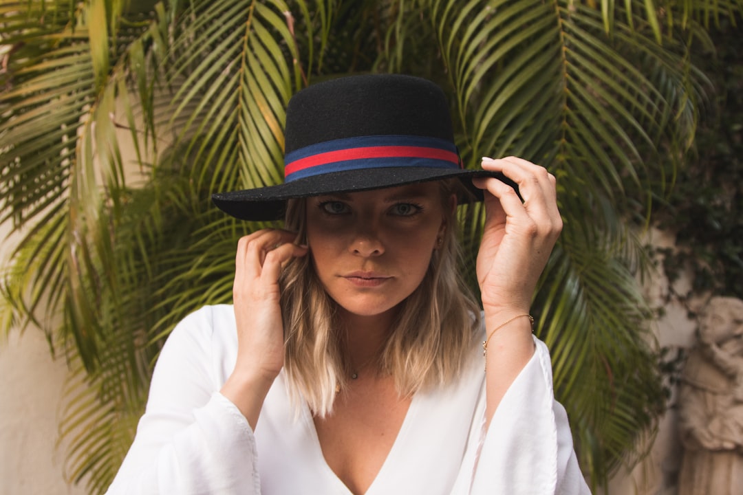 woman wearing black hat beside trees