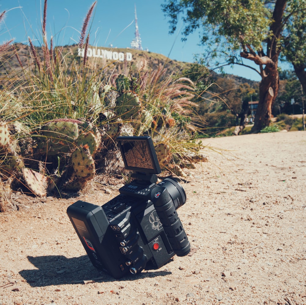 black professional video camera on floor near green grass