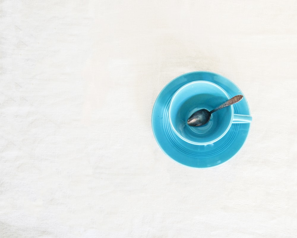 a blue bowl with a spoon inside of it