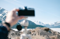 Waleed Malik capturing a scenic mountain landscape with his camera.