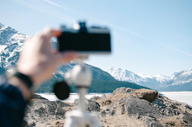 A vibrant photo of a travel influencer capturing scenic mountain views with a high-tech camera.