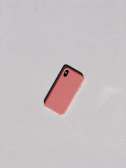 Close-up of a sleek iPhone case in pastel pink resting on a light beige surface.