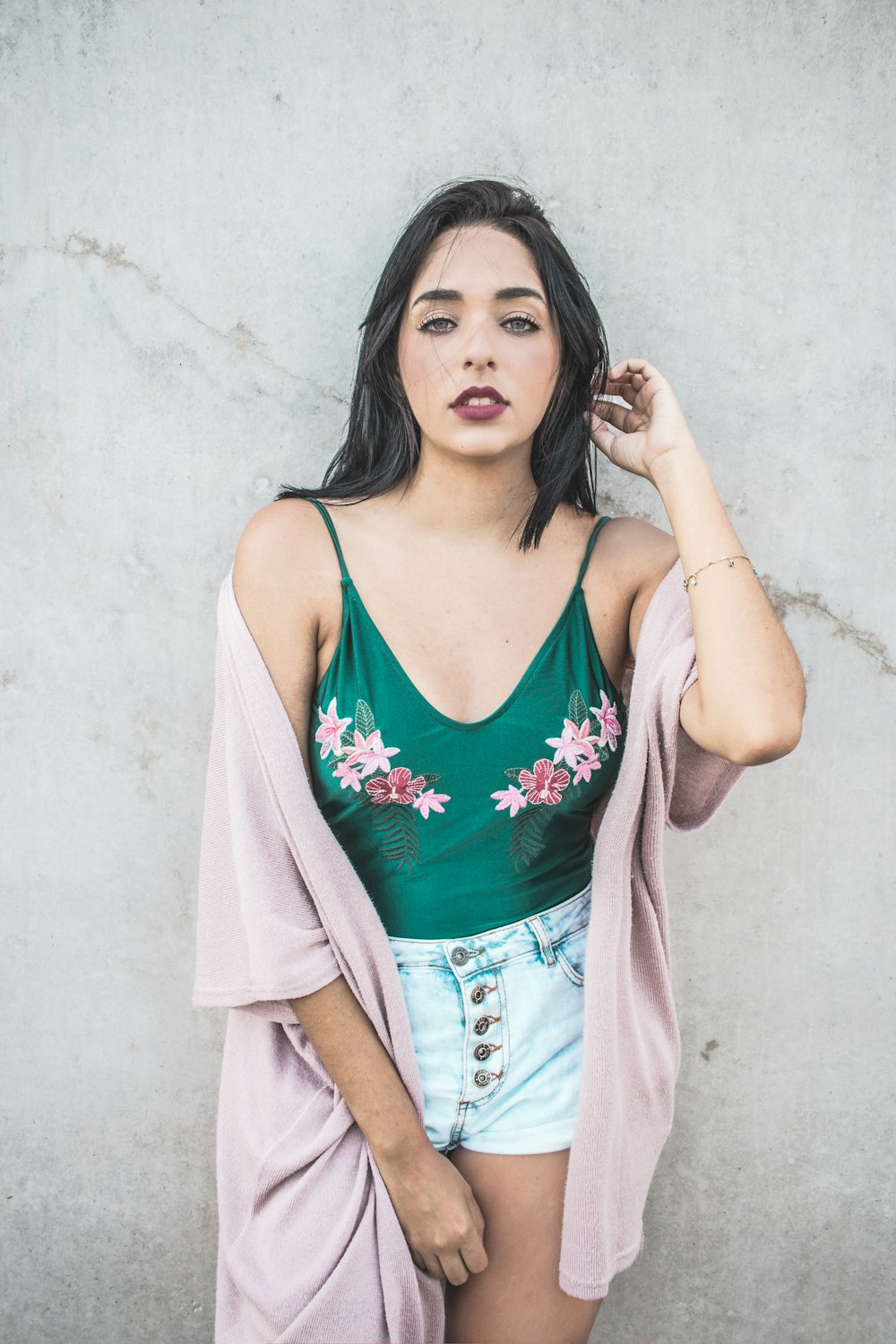 woman leaning on white wall