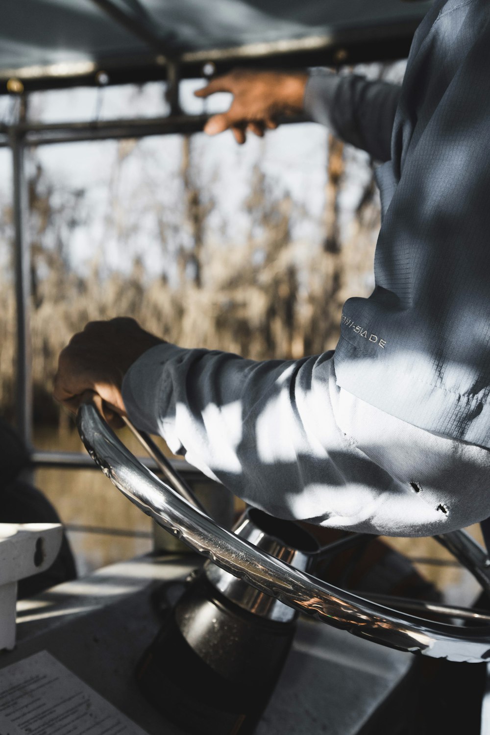 person holding boat steering wheel