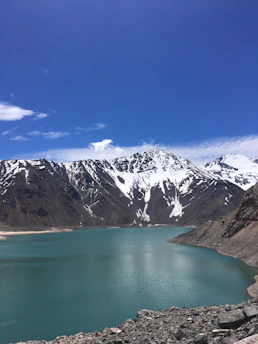 A peaceful view of Lago Chungara with mountains in the background under a clear blue sky.