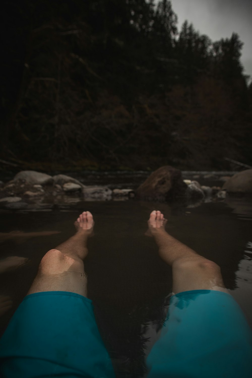 a person laying in the water with their feet in the water