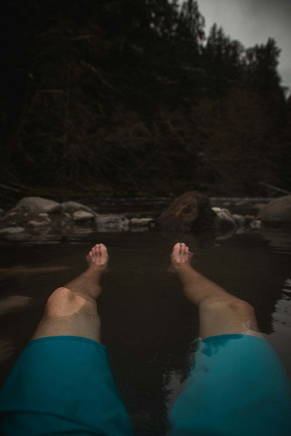una persona acostada en el agua con los pies en el agua