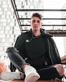 A casual outfit featuring relaxed-fit jeans and a plain grey sweatshirt on a city bench.