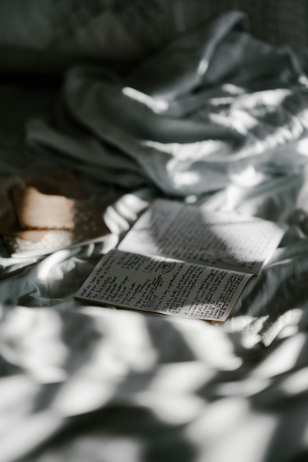 fotografía de enfoque superficial del folleto en la parte superior del textil blanco