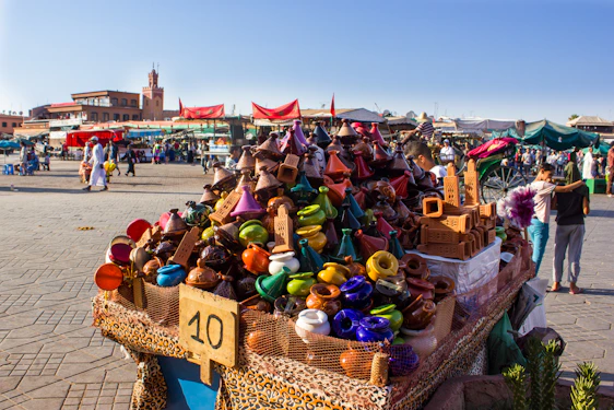 A warm photo of a local Moroccan market bustling with vibrant colors and smiling travelers.