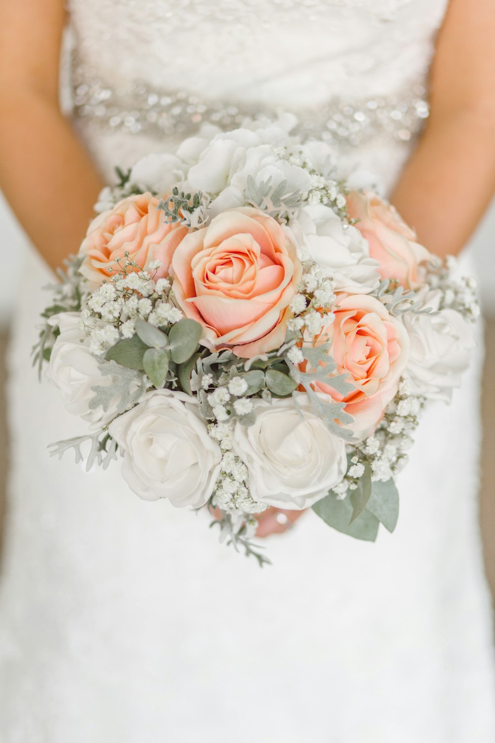 Femme tenant un bouquet de fleurs roses blanches et roses