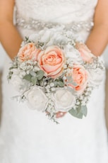 woman holding white and pink rose flower bouquet