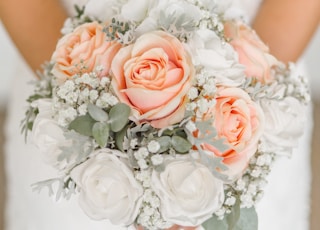 woman holding white and pink rose flower bouquet