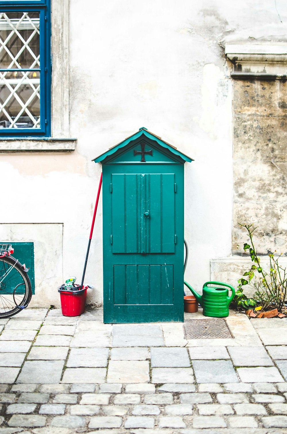 Grüner Geräteschuppen neben der Wand