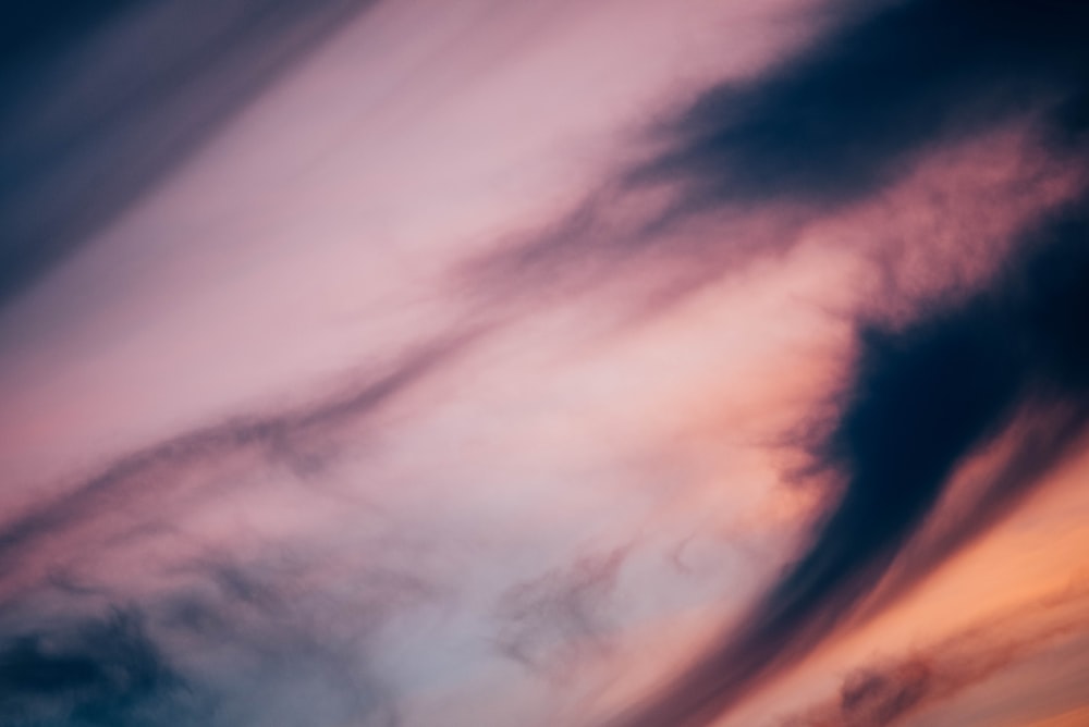 a plane flying in the sky with a sunset in the background