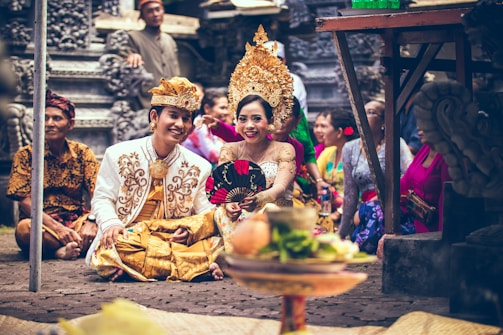man and woman sitting on area rug smiling