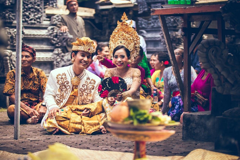 man and woman sitting on area rug smiling