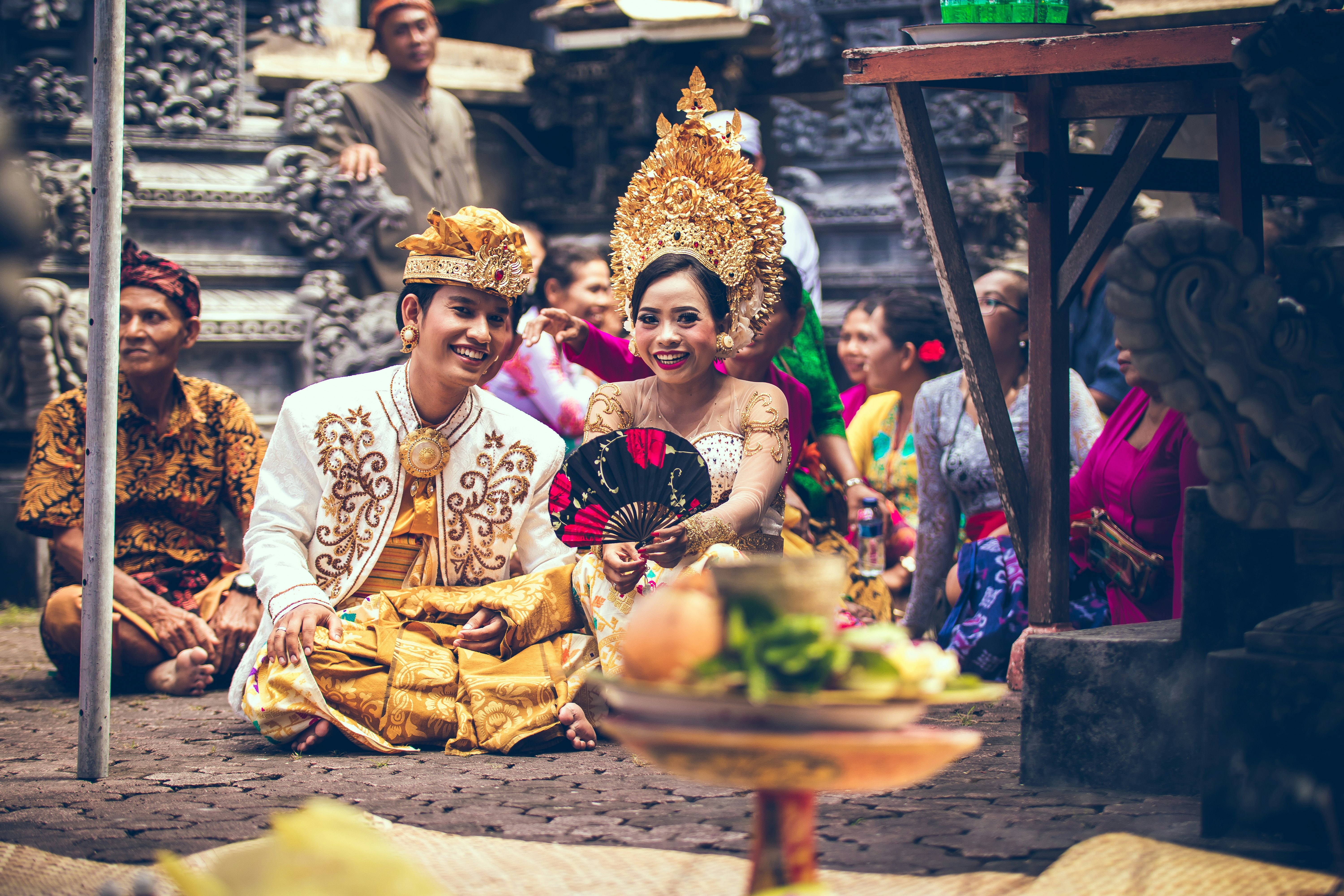 man and woman sitting on area rug smiling