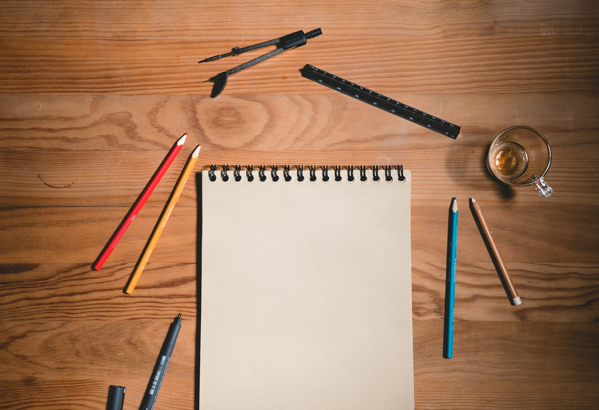 Wood table with paper sheet and drawing tools