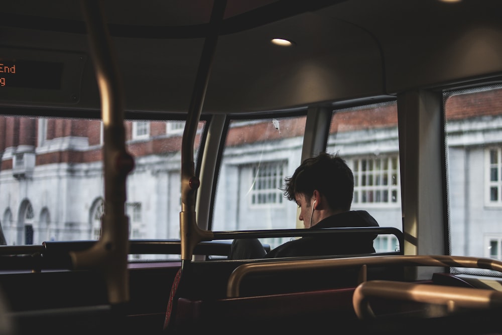 homem dentro do ônibus usando fones de ouvido