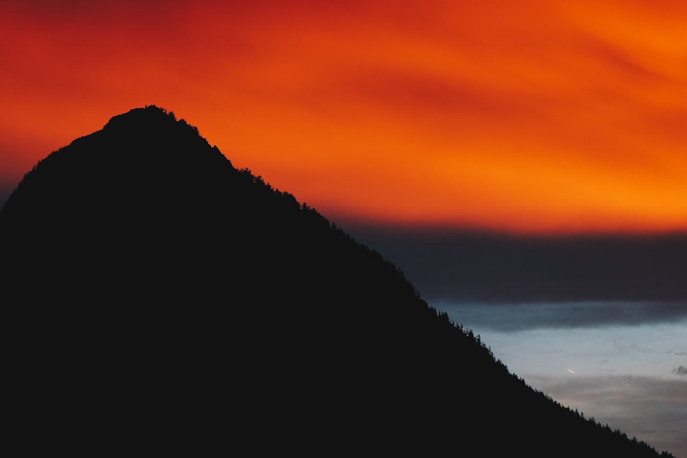 silhouette of mountain near body of water
