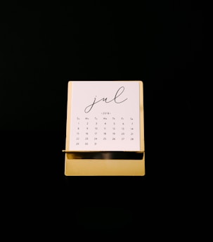 Elegant calendar marked with important real estate closing dates in gold and black.