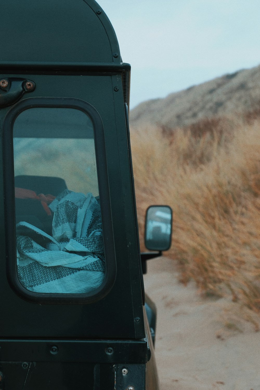 Foto de primer plano de un vehículo negro cerca de la hierba seca