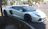 A sleek luxury sports car parked on a sunlit city street, reflecting the vibrant urban atmosphere.