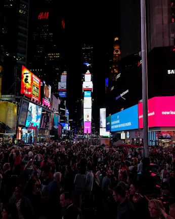 Night view of a digital OOH media panel illuminating a crowded city square.