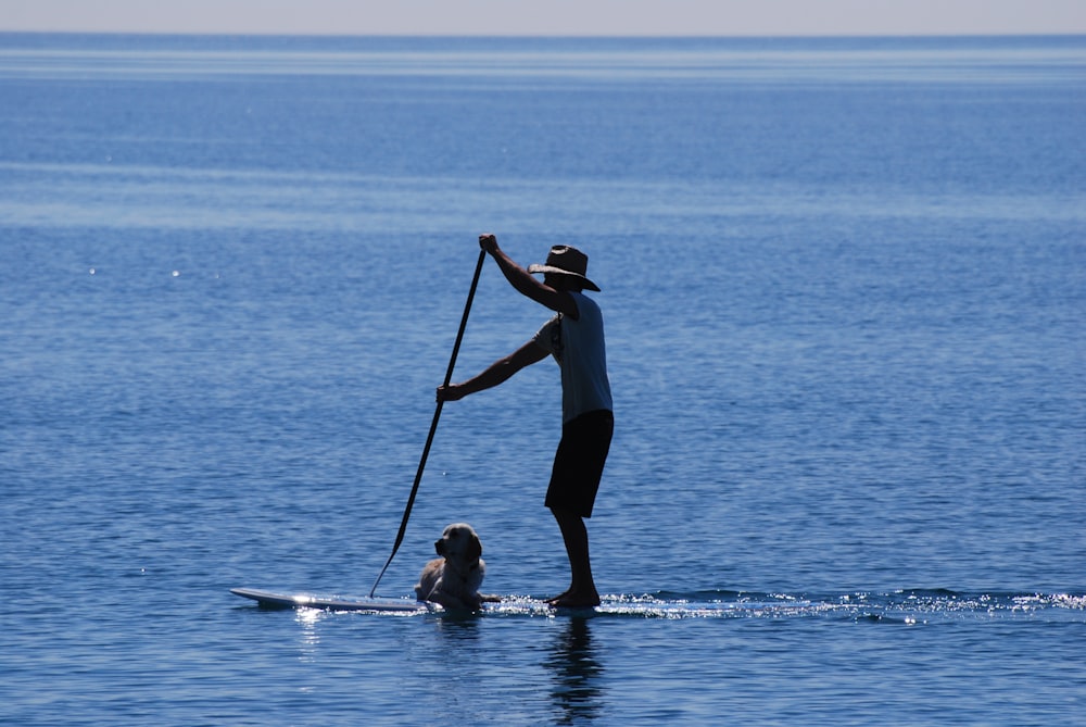 man sailing on board with dog