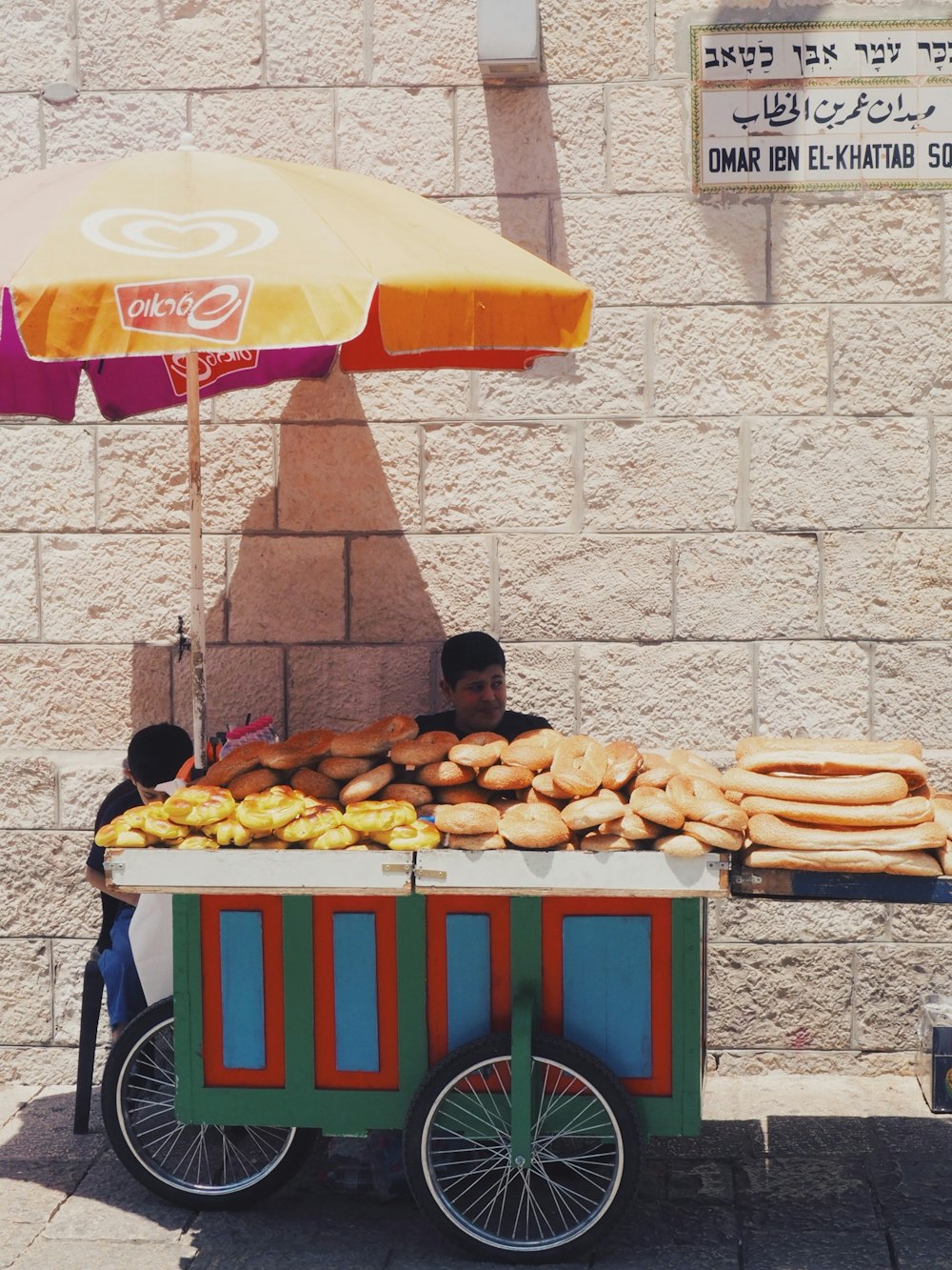 man seating beside food cart