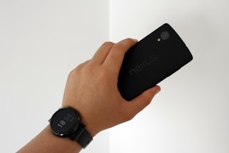 A friendly hand reaching out with a smartphone displaying the Nexus Ventures LLC contact page.