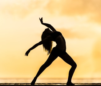 silhouette of woman making yoga pose
