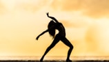 silhouette of woman making yoga pose