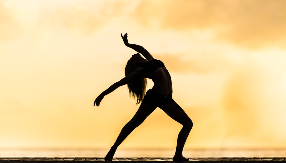 silhouette of woman making yoga pose