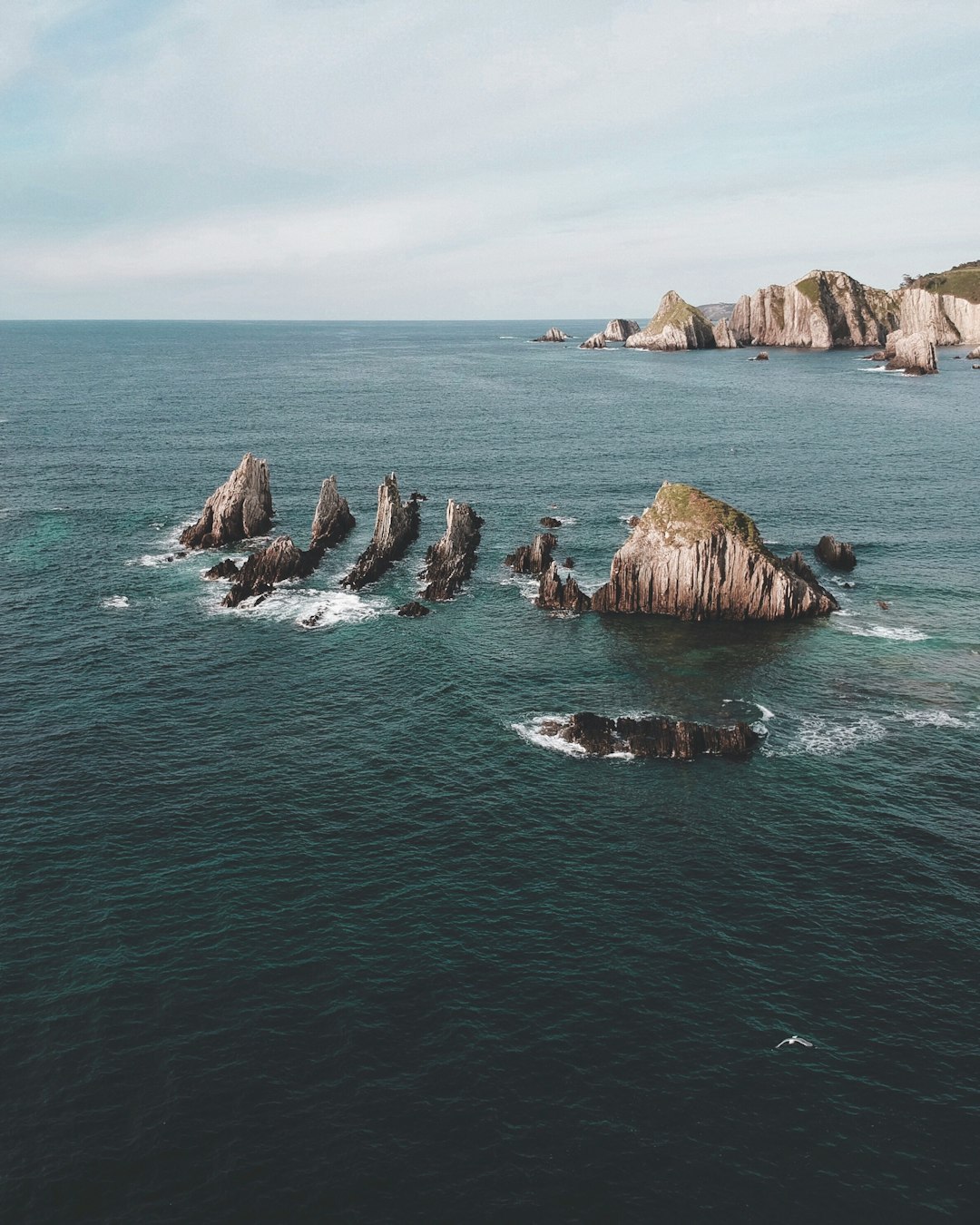 brown rock in the middle of ocean